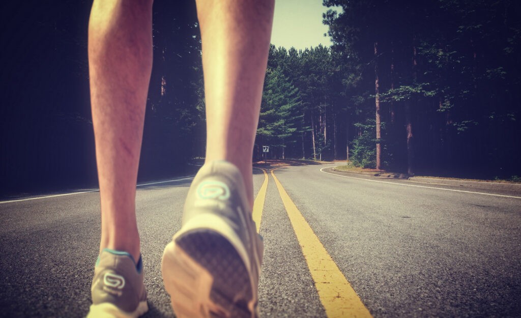 Feet of an athlete running on a deserted road - Training for fitness and healthy lifestyle