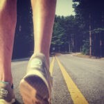 Feet of an athlete running on a deserted road - Training for fitness and healthy lifestyle